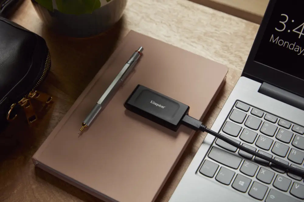 Disco duro externo Kingston XS1000 SSD de 1TB con puerto USB 3.2 Gen 2, diseño compacto y portátil.