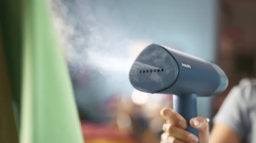 Vaporera de mano Philips 3000 series STH3000/20 para ropa, con mango y depósito de agua visible.